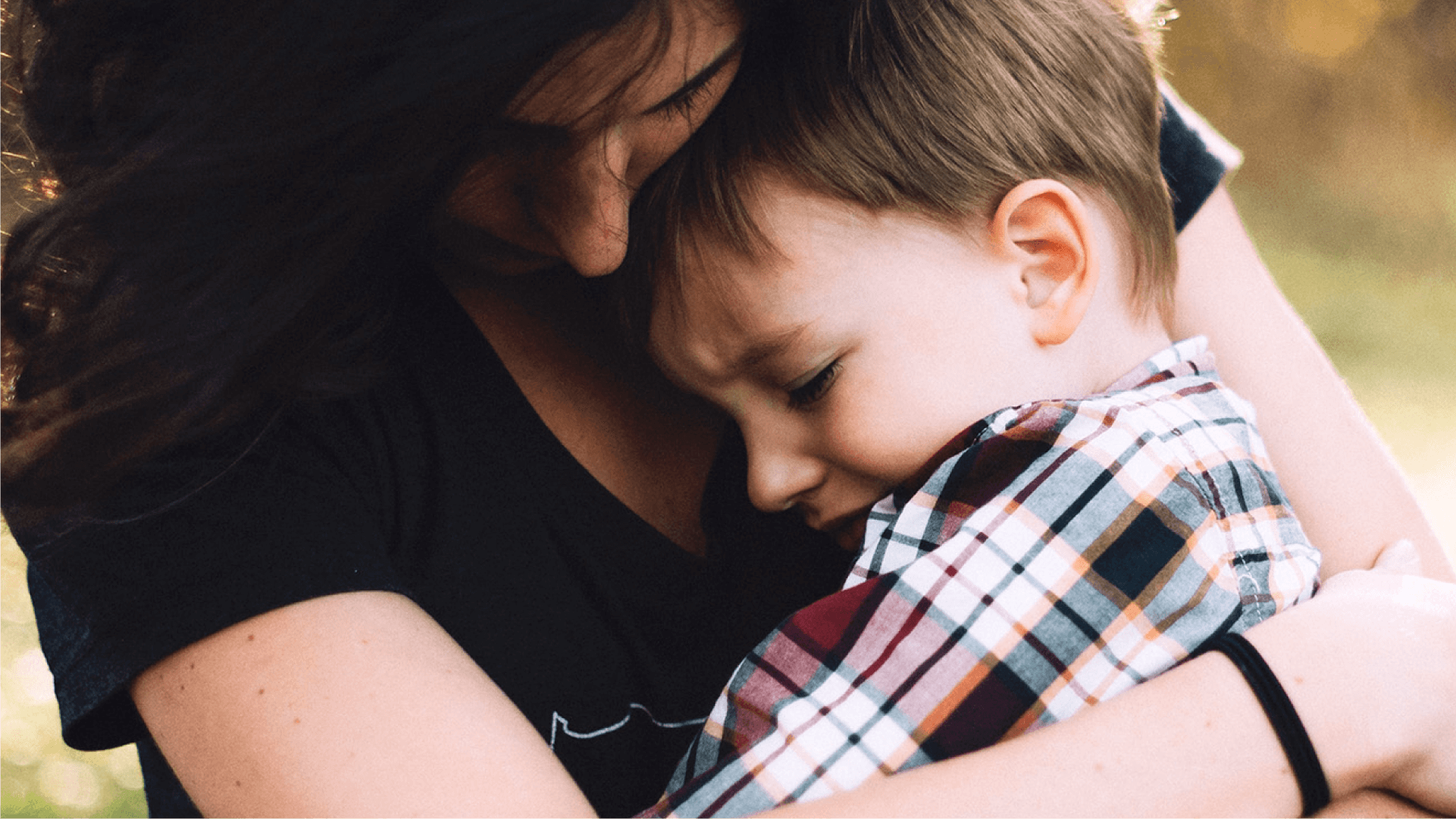 A mother hugs her upset child close to her.
