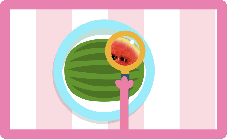 A monster hand holds a magnifying glass over a watermelon to reveal the inside.