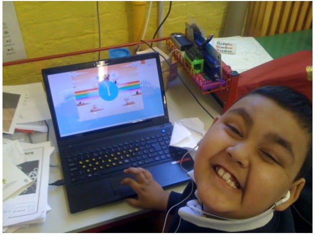 A smiling student playing Teach Your Monster to Read
