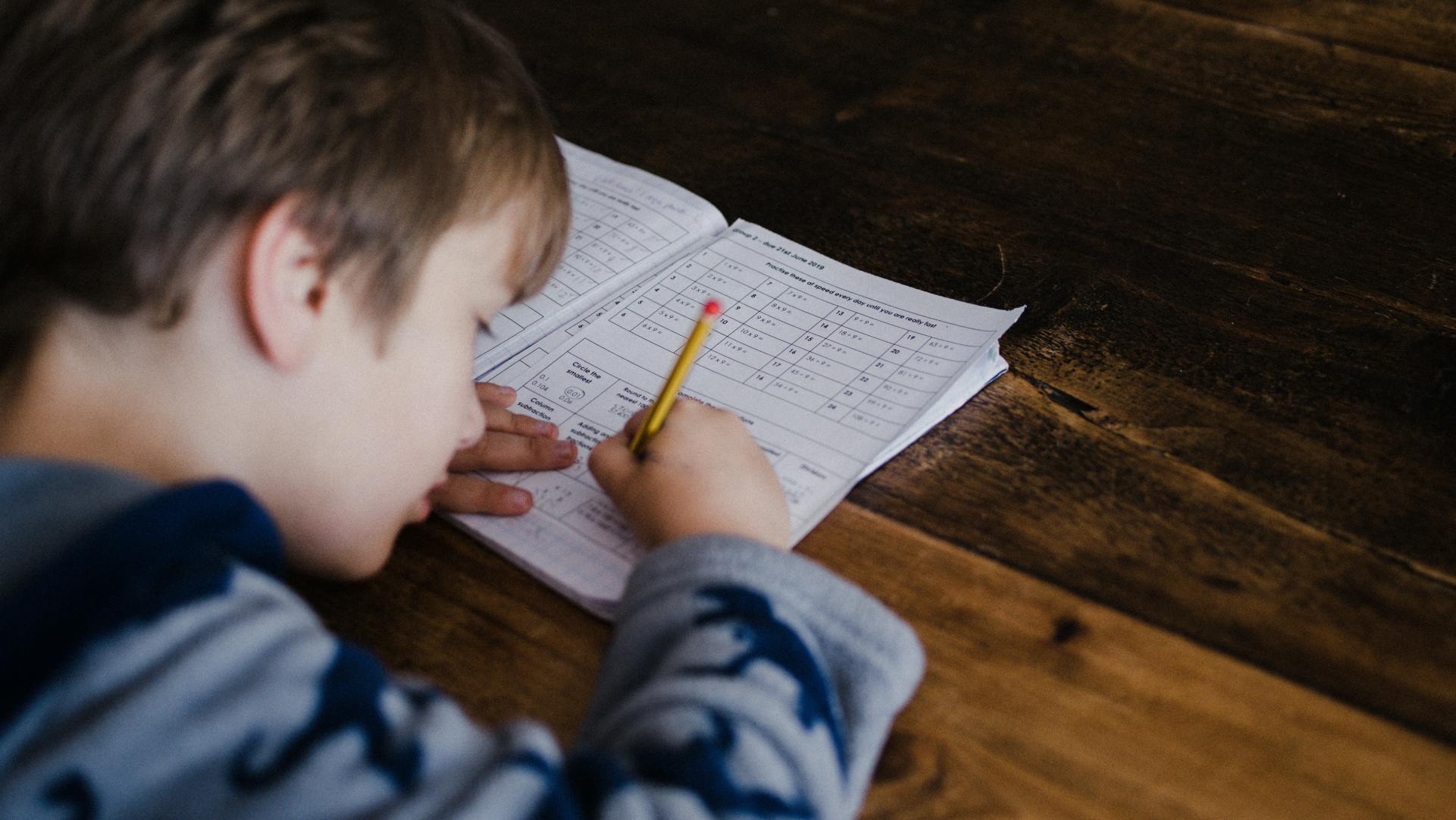 A boy writing in a school book