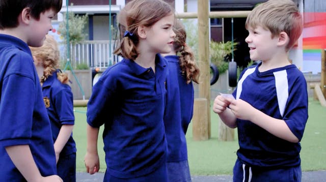 Children playing a phonics game in the playground