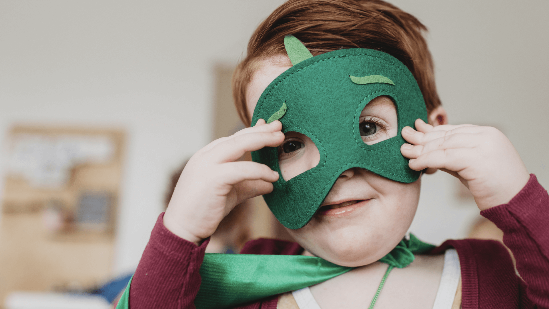A boy holding up a mask