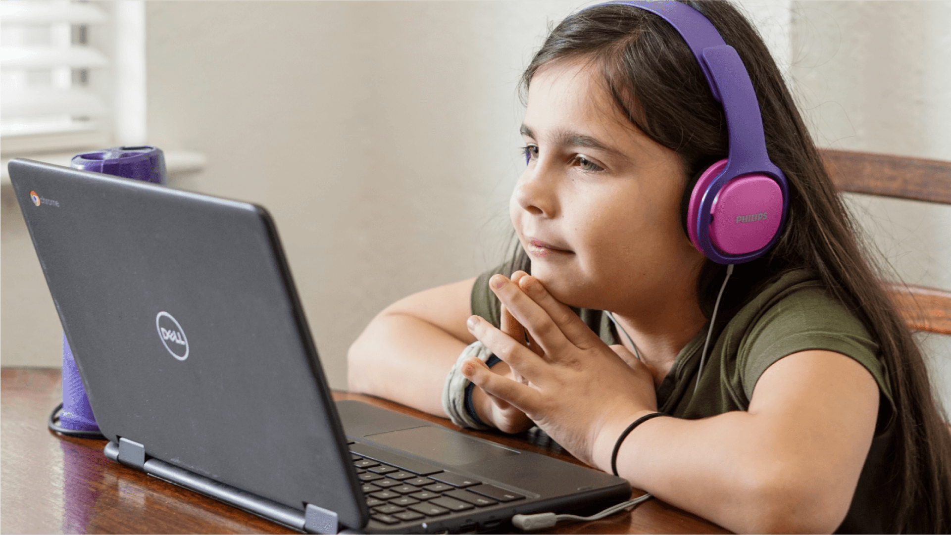 A girl with headphones on in front of a laptop