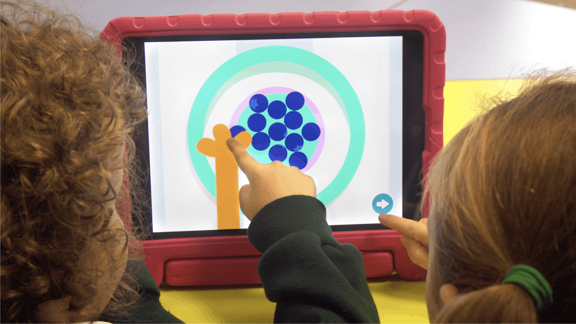 Two kids playing the touch game on iPad