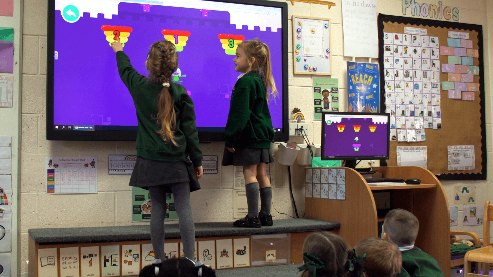 Two school children playing Number Skills on an interactive whiteboard