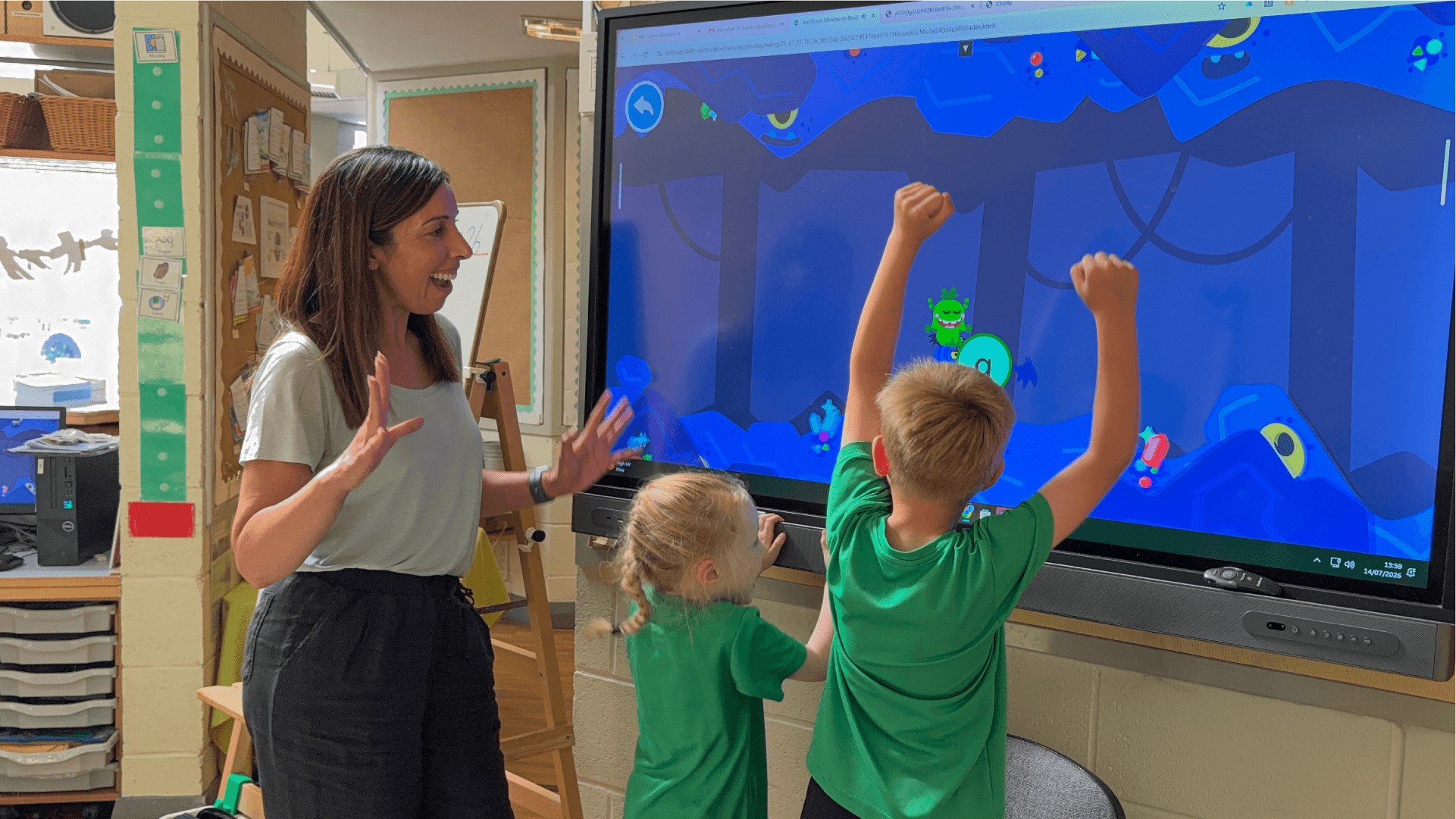 Two kids play on an interactive whiteboard in the classroom.